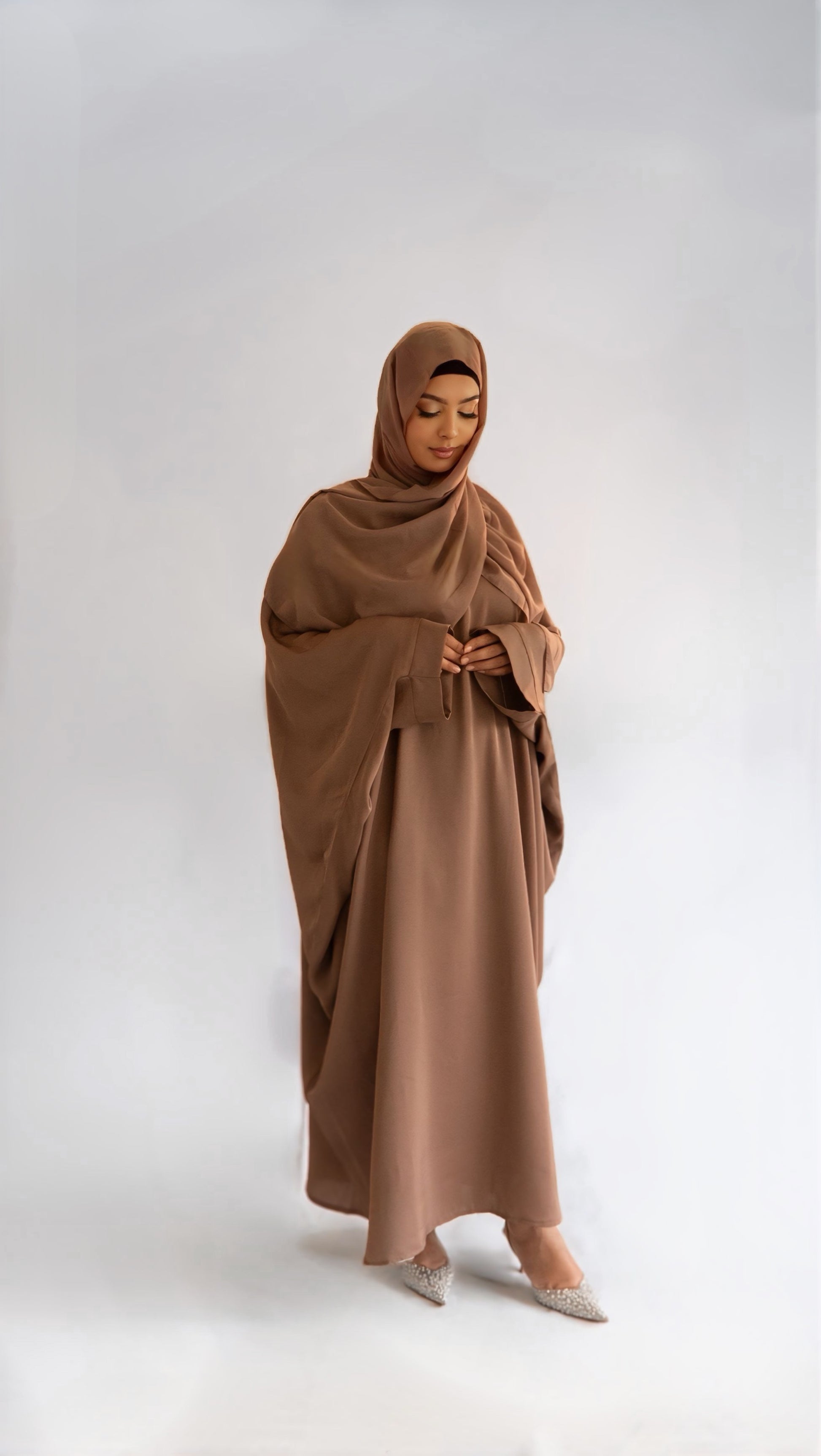 Femme portant la abaya Elegance Batwing, regardant le sol, légèrement de profil