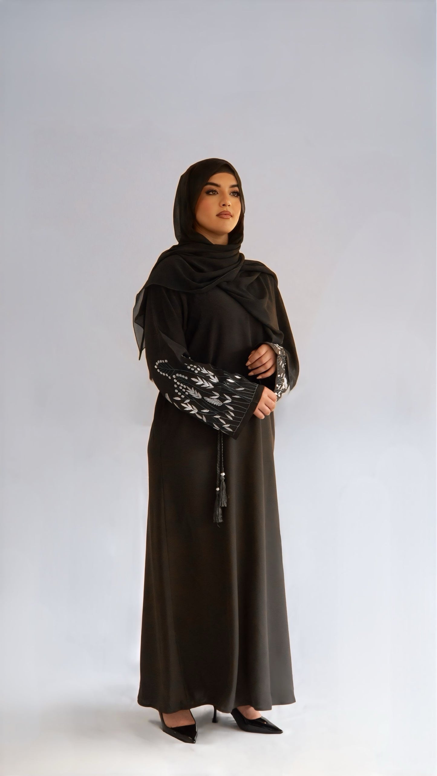 Femme de profil droit portant la abaya Olive Grace, regard à l'horizon